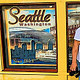 Couple smiling in front of poster wall of Seattle Washington. Empower Your Career. A woman of versatility.