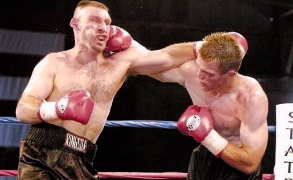Morrison (on the right) in a pro boxing match, simultaneously dodging a punch and throwing one.